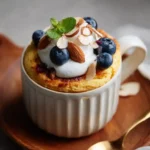 almond cottage cheese mug cake on rustic kitchen counter