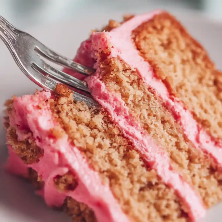 slice almond cake with raspberry frosting close up